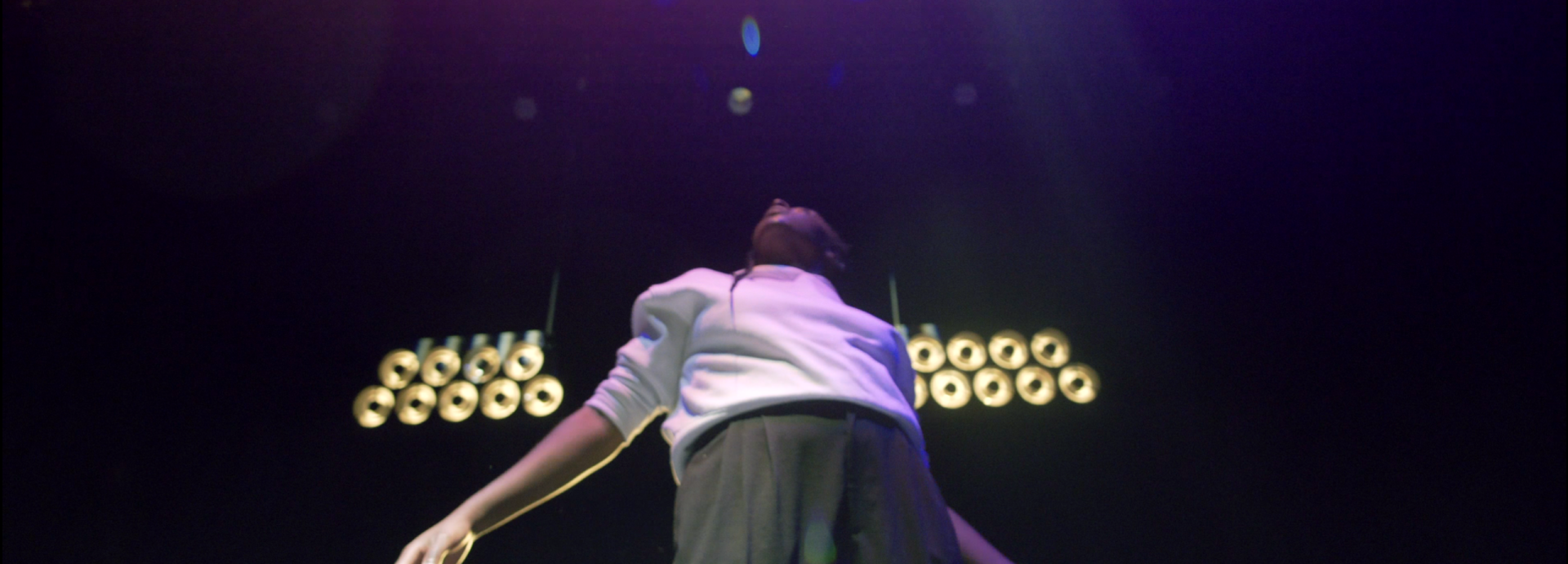  A black person standing on stage looking up